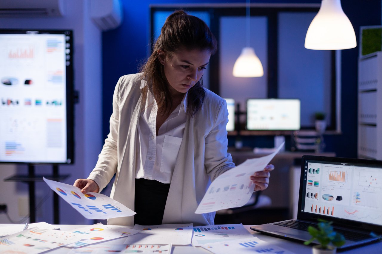 busy-business-woman-looking-financial-reports_Easy-Resize.com